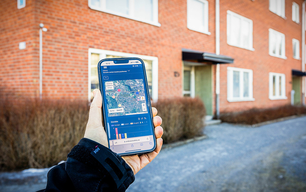 Embrace används på telefon i ett bostadsområde